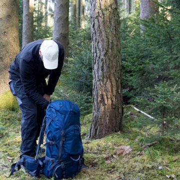 man with backpack forest wood backpacking tents